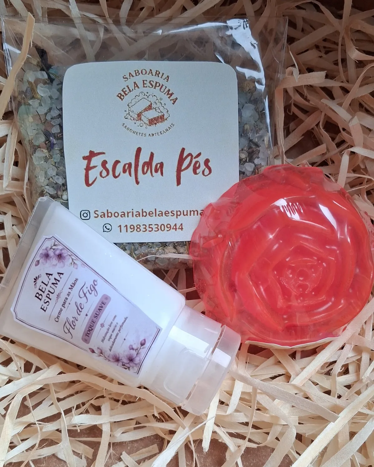 Escalda-pés, creme para as mãos Flor de Figo e sabonete vermelho em formato de rosa sobre palha de madeira