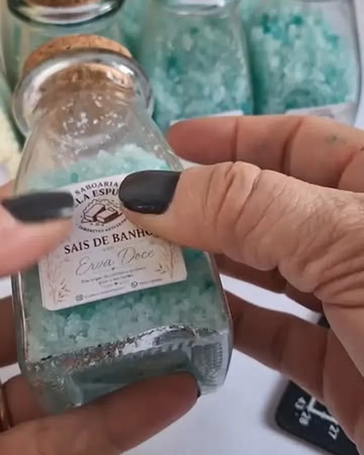Potes de vidro com sais de banho verdes e rolha